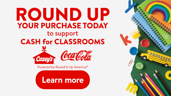 Casey's Round Up for Classrooms promotional graphic encouraging guests to round up their purchase to support local classrooms, featuring Casey's and Coca-Cola logos, school supplies, a toy school bus, and a Learn More call-to-action button.