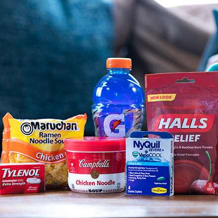 ramen, soup, Gatorade, and medicine on coffee table