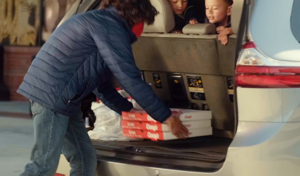 A Casey's team member putting pizza boxes in the back of a car for curbside pickup