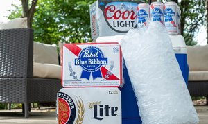 A cooler and a bag of ice with assorted packs of beer