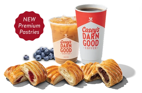 Cherry, cream cheese and chocolate pastries sitting next to a hot b;ueberry crumble coffee in a paper cup and cold blueberry crumble coffe in a clear plastic cup with blueberries in a pile