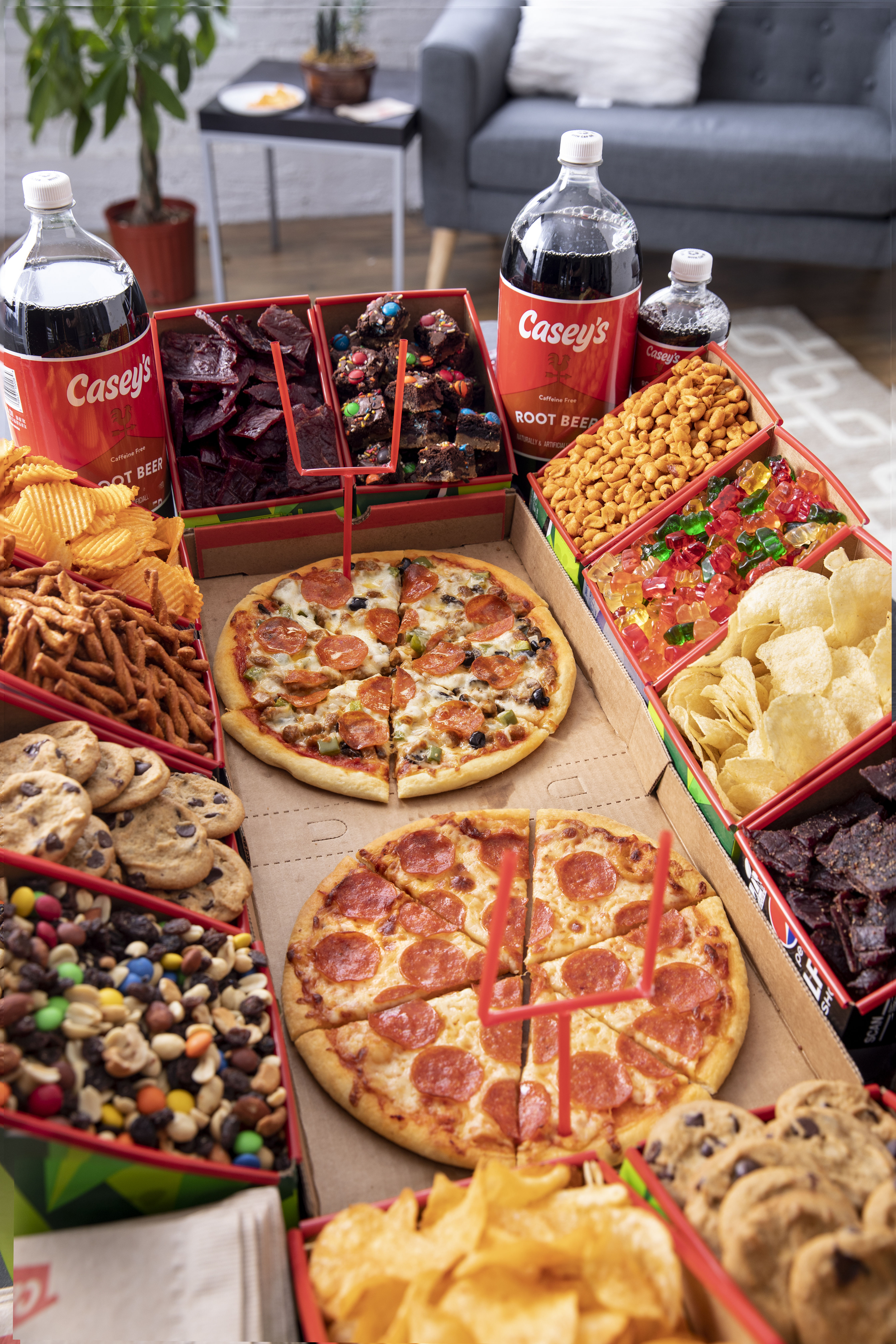 A mix of Casey's pizza, snacks, and other foods creating a football stadium