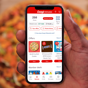 Someone holding their phone over pizza with Casey's new mobile app on the screen