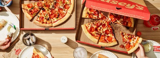 fresh food items including pepperoni pizza and supreme pizza with hands reaching for a slice of pizza and drinks