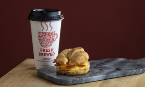 A cup of Casey's Bean-to-Cup Coffee and Bacon, Egg & Cheese Croissant breakfast sandwich