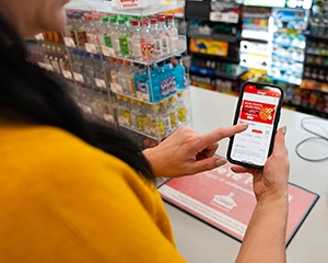 woman hodling a phone looking at the homepage of the casey's app