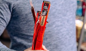 A man holding sticks of Jack Links Original Beef Jerky
