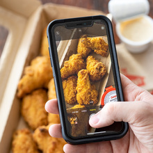 Someone taking a picture of Casey's new crispier wings and signature sauces