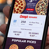 Holding phone with Casey's Rewards