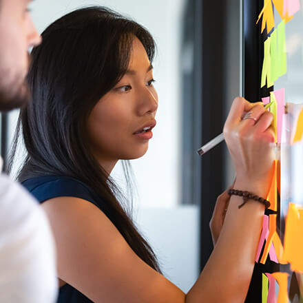 person making notes on white board