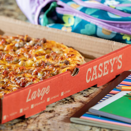 Bacon Cheeseburger Pizza with school supplies on counter