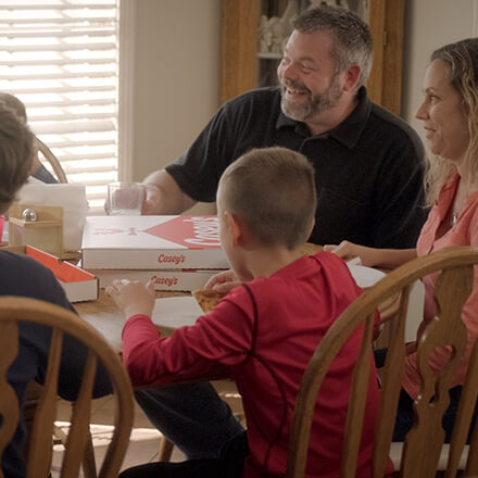 family eating pizza around a table