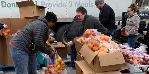 Volunteers sorting oranges to distribute to families