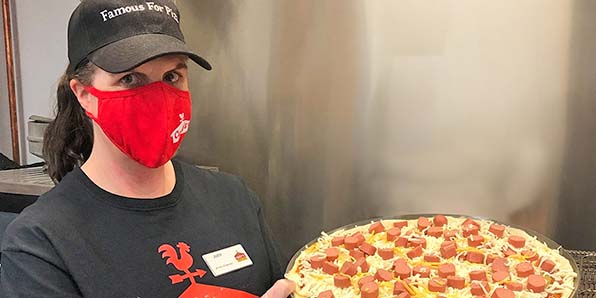 Casey's team member with a pizza