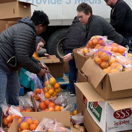 Volunteers sorting oranges to distribute to families