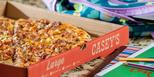 Bacon Cheeseburger Pizza with school supplies on counter