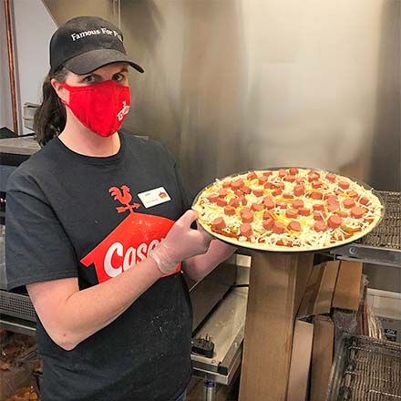 Casey's team member with a pizza