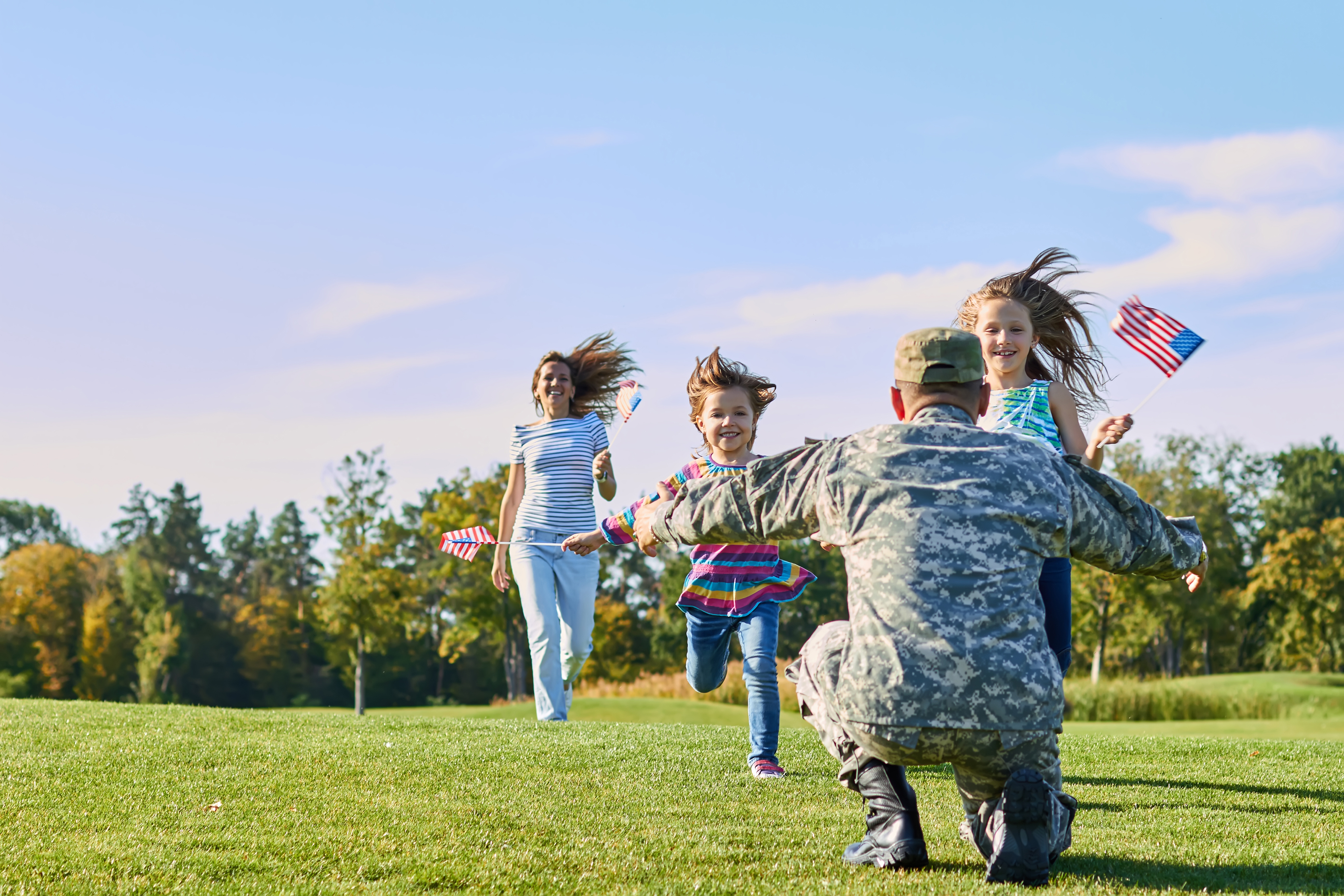 Soldier meeting his family outside on the grass